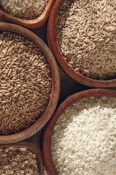 Set of different types of rice and cereals in wooden bowls Stock Photos