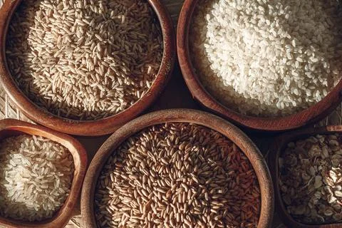 Set of different types of rice and cereals in wooden bowls Stock Photos