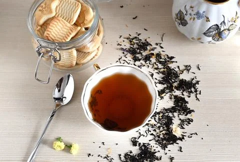 A set of different types tea next to the kettle filled with hot brewed tea on Stockfoto's