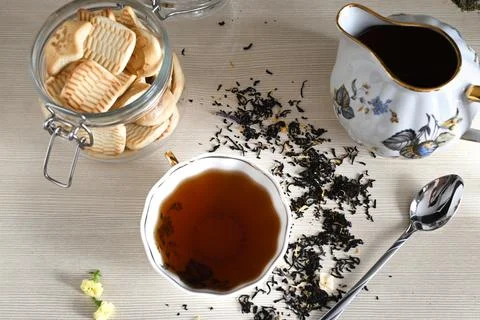 A set of different types tea next to the kettle filled with hot brewed tea on Stock Photos