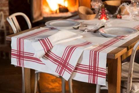 Set Dinnerware and Tablecloth with Red Stripes Near Blazing Fireplace Foto stock