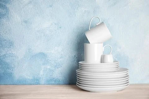 Set of dinnerware on table against color background with space for text. Inte Foto stock