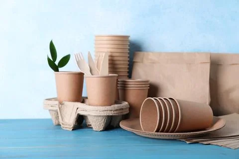 Set of disposable eco friendly dishware on light blue wooden table Stock Photos