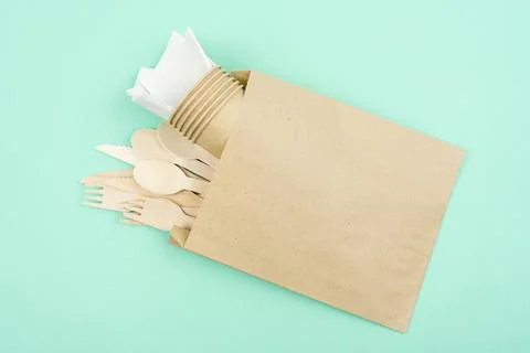 Set of disposable tableware and wooden cutlery in a craft package Stock Photos