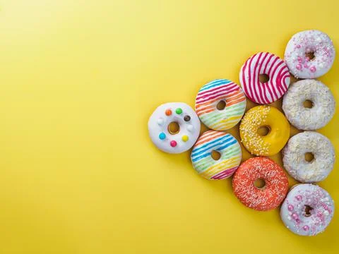 Set of donuts on yellow background. Stock Photos
