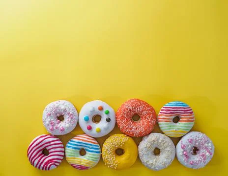 Set of donuts on yellow background. Stock Photos