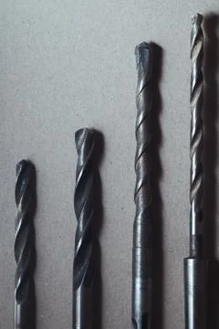 Set of drill bits on wooden background. Stock Photos