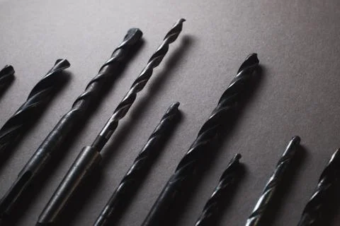 Set of drill bits on wooden background. Stock Photos