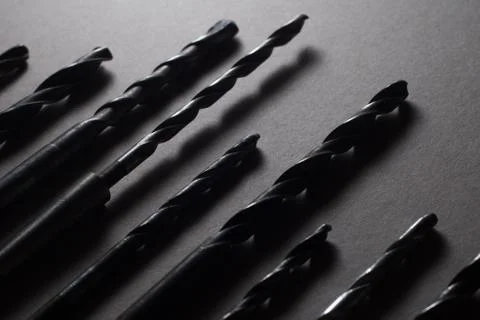 Set of drill bits on wooden background. Stock Photos