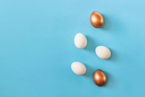 Set of Easter white and golden color eggs isolated on blue background. Stylish Stock Photos
