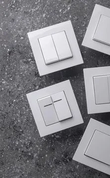Set of electrical switch covers and switches on textured surface Stock Photos