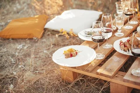 Set of elegant glassware placed on plank wooden table with floral arrangement on 스톡 사진