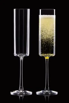 Set of empty and full champagne glasses isolated on black background. Stock Photos