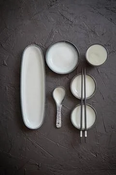 Set of empty ceramic dishes for sushi and rolls on a black stone table Set... Stock Photos