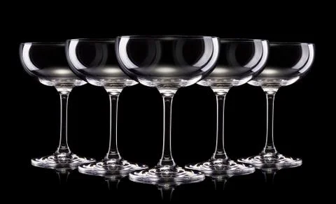 Set of empty champagne glasses in a row isolated on a black background Stock Photos