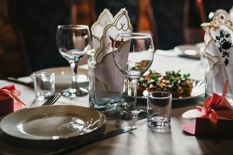 Set of empty glasses and plates with Cutlery on a white tablecloth on the table Stock Photos