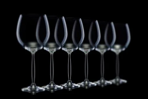 Set of empty glasses for red wine in a row isolated on black background. Stock Photos