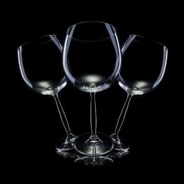 Set of empty glasses for red wine in a row isolated on black background. Stock Photos