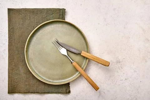 Set of empty green plate with fork and knife on white textured background Stock Photos