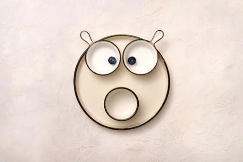 Set of empty light dishes in the form of animal face in the eyes of berries Stock Photos