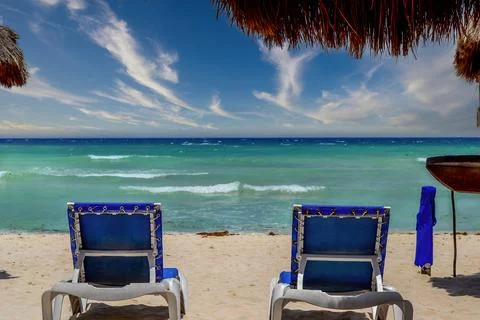 Set of empty long chairs in front of the ocean Stock Photos
