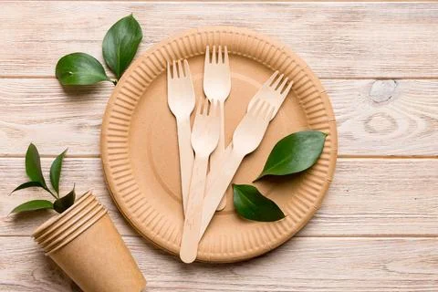Set of empty reusable disposable eco-friendly plates, cups, utensils on lig.. Stock Photos