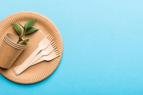 Set of empty reusable disposable eco-friendly plates, cups, utensils on lig.. Stock Photos