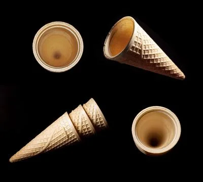 Set of Empty waffles cones hanging in the air on black background. Stock Photos