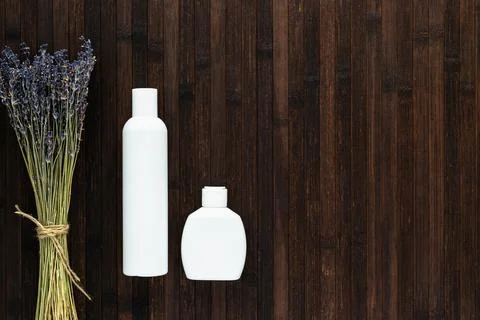 A set of empty white bottles with cosmetics and a bouquet of lavender on a da Stock Photos