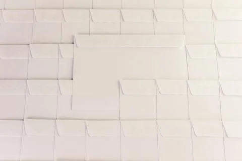 Set of empty white envelopes lying in a row on a desk in the office, one enve Stock Photos