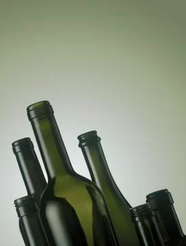 Set of empty wine bottles on green background Photos