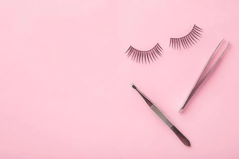 Set of false eyelashes extencions on pink background with tweezers. Minimalis Stock Photos