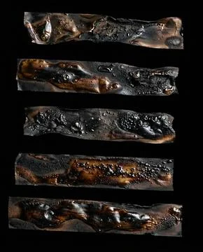 A set of five completely charred sticker remnants. 스톡 사진