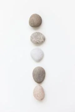 Set of five pebbles in a row on the white background Stock Photos