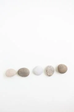 Set of five pebbles in a row on the white background Stock Photos
