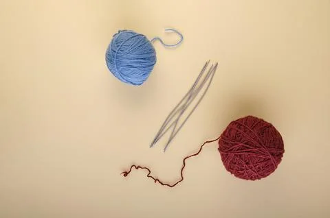 A set of five short knitting needles lies next to neat skeins of beautiful .. Stock Photos