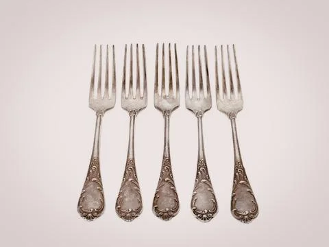 Set of five vintage silver forks with ornate handles Stock Photos