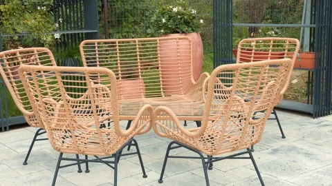 Set of five wicker chairs and a bench are arranged in a circle on a patio Stock Footage 299355033