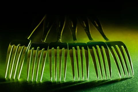 A set of forks in a raw with gradient colourful led light. Stock Photos