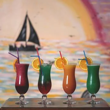 Set of four cocktail drinks on table. Colored Beverage in long glass goblets Stock Photos
