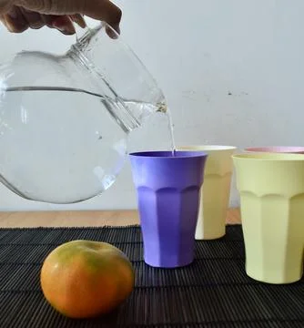 Set of Four Pastel Plastic Drinking Cups on a Japanese Bamboo Mat Stock Photos