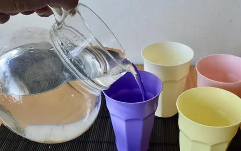 Set of Four Pastel Plastic Drinking Cups on a Japanese Bamboo Mat Stock Photos
