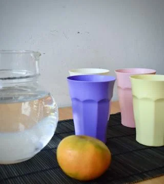 Set of Four Pastel Plastic Drinking Cups on a Japanese Bamboo Mat Stock Photos