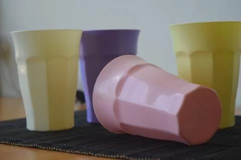 Set of Four Pastel Plastic Drinking Cups on a Japanese Bamboo Mat Stock Photos