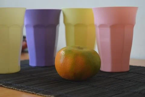 Set of Four Pastel Plastic Drinking Cups on a Japanese Bamboo Mat Stock Photos