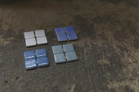 Set of four pool tiles in different colours on an old wooden table Stock Photos