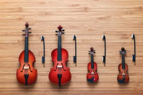 Set of four toy string musical orchestra instruments: violin, cello, contrabass Stock Photos