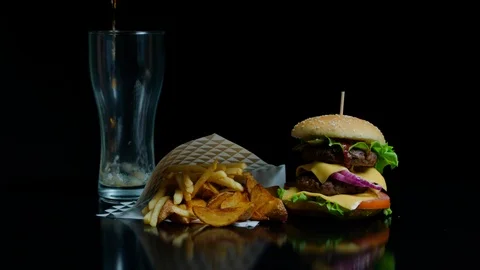 Set of french fries, burger and glass with coca-cola on the black background for Stock Footage 92492653