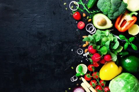 Set of fresh vegetables on a black background. Aromatic herbs, onion, avocado Stock Photos