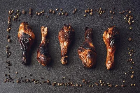 Set of fried chicken on the black background. Aromatic peppers frame. Top vie Stock Photos